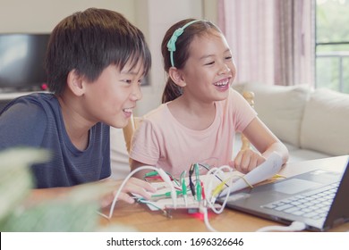 Mixed Race Young Asian Children Having Fun Learning Coding Together, Learning Remotely At Home, STEM Science, Homeschooling Education, Fun Social Distancing, Isolation, New Normal Concept