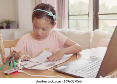 Mixed Race Young Asian Girl Learning Coding Together, Kid Learning Remotely At Home, STEM Science, Homeschooling Education, Social Distancing, Isolation, New Normal Concept