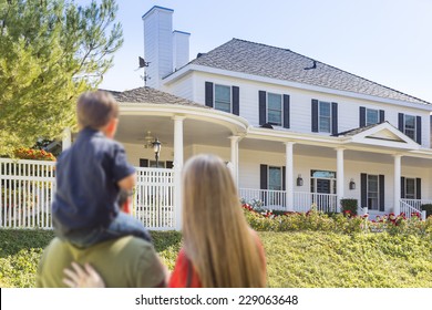 Mixed Race Young Family Looking At Beautiful New Home.