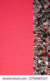 Mixed screws nuts and bolts creating border on red background with large copy space