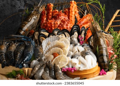 Mixed seafood contain crabs, scallops, mussels, shrimps, squids with lemon on wood bowl.Big set of various fresh sea food on wooden table background. - Powered by Shutterstock