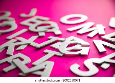 Mixed solid letters pile close up view photo. Education concept on pink background.