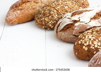 Mixed whole grain health breads on rustic white painted wood. - Shutterstock ID 275453438
