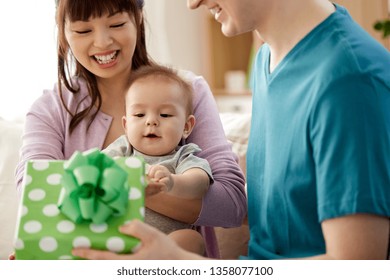 Mixed-race Family, Parenthood And Mothers Day Concept - Happy Mother, Father And Baby Son With Gift Box At Home