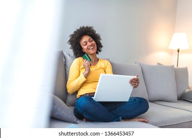 Mixed-race Woman Shopping On Internet. Woman Is Holding Credit Card And Using Laptop Computer. Online Shopping Concept. Picture Showing Pretty Woman Shopping Online With Credit Card