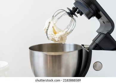 Mixer Bowl Of Whipped Cream. White Kitchen Background. Homemade Culinary Concept. Mixing, Whipping Cream For Cake. Concept Of Confectionery, Cooking Desserts And Kitchenware, Homemade Culinary.