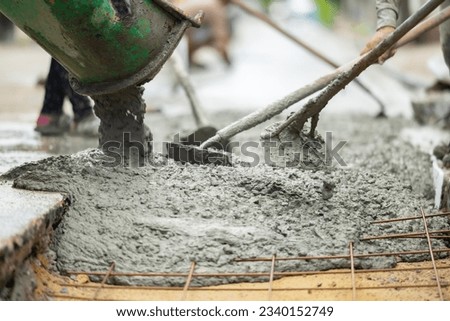 Mixer truck pouring cement concrete casting on reinforcing metal bars of sidewalk. Concrete mixer truck, transport and combine cement and water in revolving drum. Worker using shovel and scoop at work