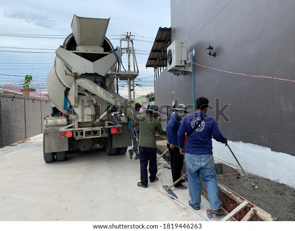 Mixer truck is transporting\
cement at building site, control by workers. Thailand September\
2020