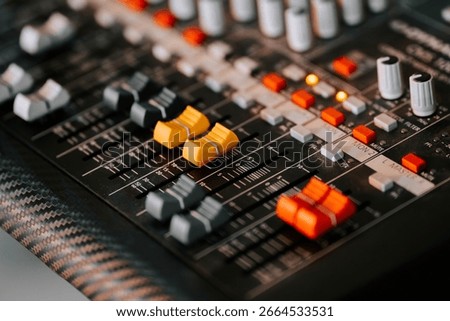 Mixing board with colorful knobs and sliders in a recording studio