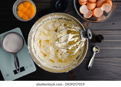 Mixing Bowl Filled with Vanilla Swiss Meringue Buttercream: Wire whisk attachment resting in a bowl of vanilla buttercream frosting or icing - Powered by Shutterstock