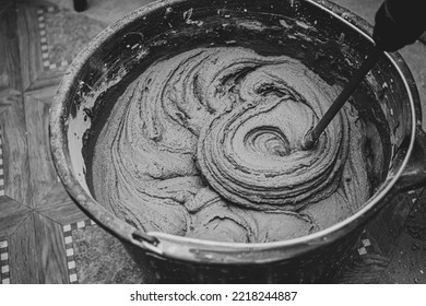 mixing cement adhesive with a mixer in a bucket close-up, texture of a mixed mortar