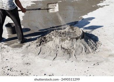 Mixing cement by hand using a shovel to mix sand, stone, cement and water before construction. - Powered by Shutterstock