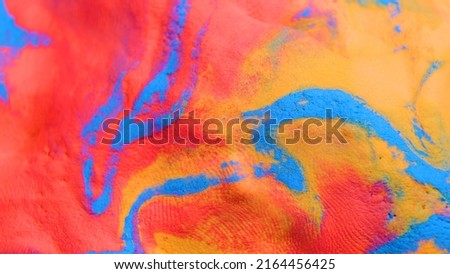 Mixing colours Blue, red and yellow creating pattern pink paint. close up relief, selective focus