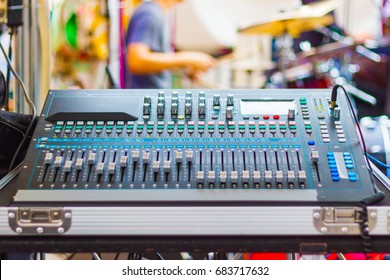 Mixing Console of a big HiFi system The audio equipment, control panel of digital studio mixer. with Musicians playing music background 