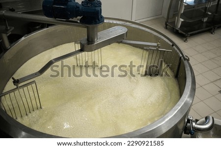 Mixing curd and whey in tank at cheese factory, top view. Copy space