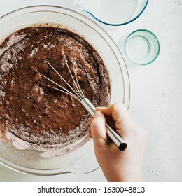 mixing dough for chocolate cake in a bowl. female hands and a kitchen whisk. recipe step by step - Powered by Shutterstock