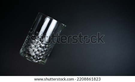 A mixing glass on a black background