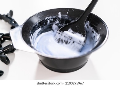 Mixing Hair Color Dye In A Black Mixing Bowl With A Brush.