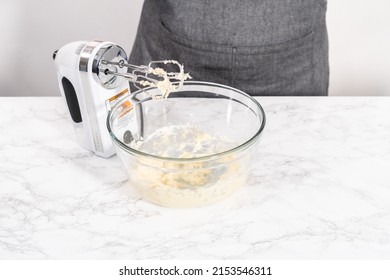 Mixing Ingredients In A Large Glass Mixing Bowl To Prepare Cream Cheese Drizzle Sauce.