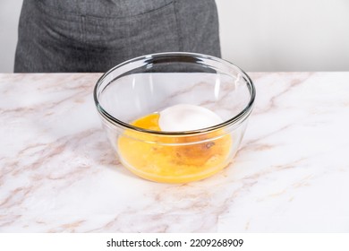 Mixing ingredients in a large glass mixing bowl to bake apple sharlotka muffin. - Shutterstock ID 2209268909