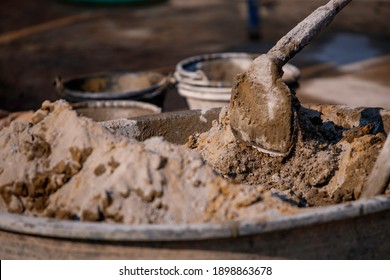 Mixing mortar using a hoe has been a long-established construction task and is a costly construction tool. - Shutterstock ID 1898863678