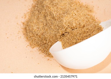 Mixture of dietary supplements. White can of dietary fiber and scoop on a beige background. Dietary herbal supplements, biologically active additives for gut health. Top view, close up.