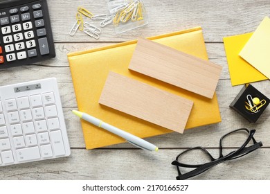 A mixture of stationery keyboard calculator glasses yellow sticker. on a wooden table background. wooden blocks for entering text on a yellow notepad. View from above.