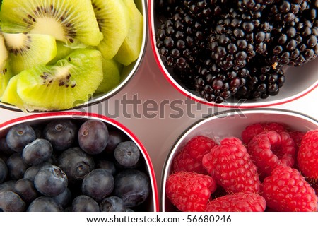 Mixture of summer fruit in black and red bowls