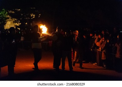 Miyajima, Japan - December 31, 2019. Participants Of The Chinkasai Fire Festival At Itsukushima Shrine, Near Hiroshima, Carry Large Burning Torches Around The Sea Shore As Part Of A Ritual To