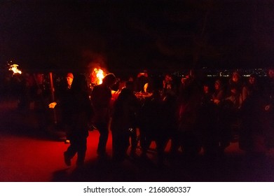 Miyajima, Japan - December 31, 2019. Participants Of The Chinkasai Fire Festival At Itsukushima Shrine, Near Hiroshima, Carry Large Burning Torches Around The Sea Shore As Part Of A Ritual To