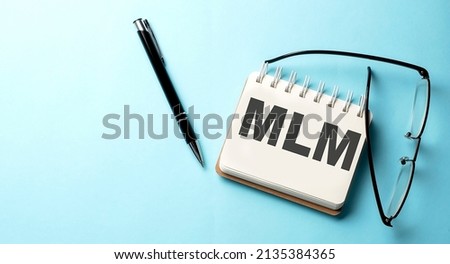 MLM text is written on notepad on the blue background
