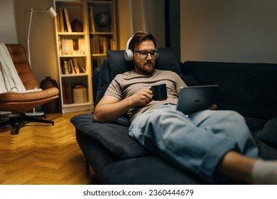 A mn is using digital tablet n the evening. - Powered by Shutterstock