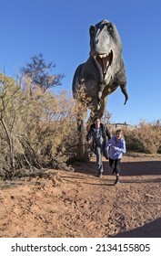 Moab, Utah, USA - November 22, 2021: T Rex Dinosaur Replica With People Running Away And Scared On The Moab Giants Dinosaur Trail