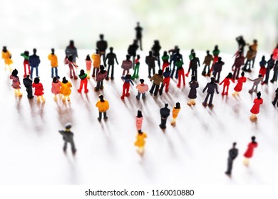 Mob, crowd, or community of people follows one person up a hill. Big group follows a leader. Business people working towards a common goal. Crowd of unrecognizable humans working together,