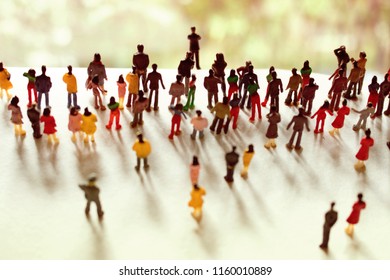 Mob, crowd, or community of people follows one person up a hill. Big group follows a leader. Business people working towards a common goal. Crowd of unrecognizable humans working together,