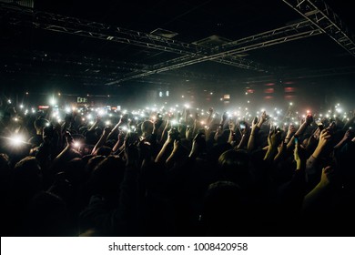 Mob Of Fans Holding Torch Lights In Theirs Hands In Face Of The Stage. Atmosphere Of The Concert. Cheering Crowd.