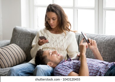 Mobile Addiction Concept, Young Couple Ignoring Each Other Using Smartphones Relaxing On Sofa, Millennial Man And Woman Obsessed With New Apps Or Social Networks, Phone Addicts Lost In News Online