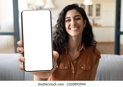 Mobile Advertisement. Happy Beautiful Woman Showing Big Blank Smartphone At Camera While Sitting On Couch At Home, Young Female Demonstrating Phone With White Screen For App Design, Collage, Mockup - Shutterstock ID 2103892994