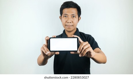 Mobile App Advertisement. Asian Man hold At White Empty Smartphone Screen Posing Over White Studio Background, Smiling To Camera. Check This Out, Cell Phone Display Mock Up - Shutterstock ID 2280853027