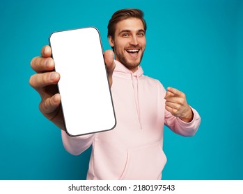 Mobile App Advertisement. Handsome Excited Man Showing Pointing At Empty Smartphone Screen Posing Over Light Blue Studio Background, Smiling To Camera. Check This Out, Cellphone Display Mock Up - Shutterstock ID 2180197543