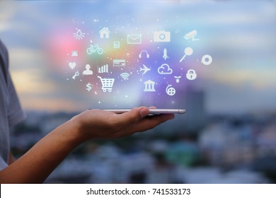Mobile application concept.Man using touch screen smart phone on blurred urban city background - Shutterstock ID 741533173
