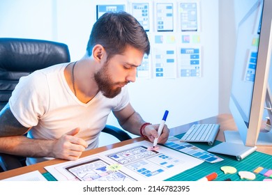 Mobile Application Design. Creation Of Sketch Of Application Interface. Male Web Designer. UX Designer Draws Apps On Paper. Web Architect At His Desk. Concept - Creation Of Financial Apps. Fin Tech