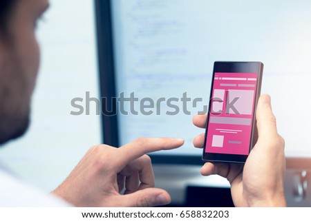 mobile application development - programmer with smartphone in hand