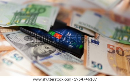 Mobile banking and finance concept: smartphone with stock exchange market application, euro and US dollar banknotes. Business background. Blurred concept