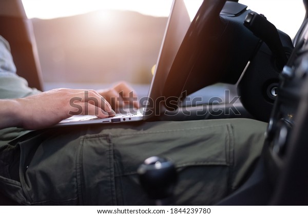 Mobile car service engineer checking\
car with his laptop on the road. Road assistance\
concept