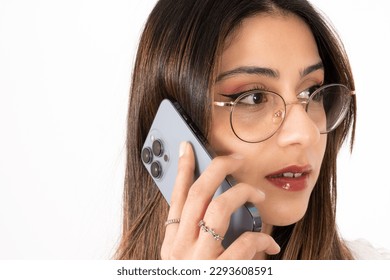 Mobile communication concept, close up side view image of mobile communication concept. Beautiful caucasian woman talking on the phone. Serious gesture face.  Brunette girl wearing glasses. Copy space