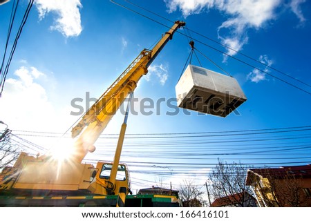 Mobile crane operating by lifting and moving an heavy electric generator 