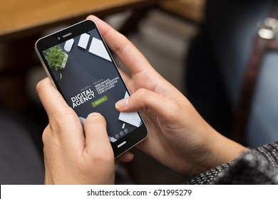 mobile design concept: girl using a digital generated phone with cool digital agency website on the screen. All screen graphics are made up.