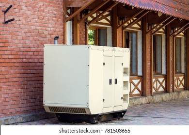 Mobile generator of emergency power supply, diesel generator installed near the wall of red brick.