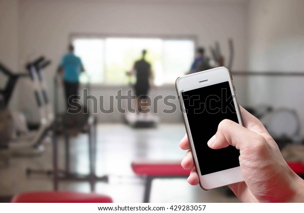 Mobile hold in hand\
with blur fitness gym
